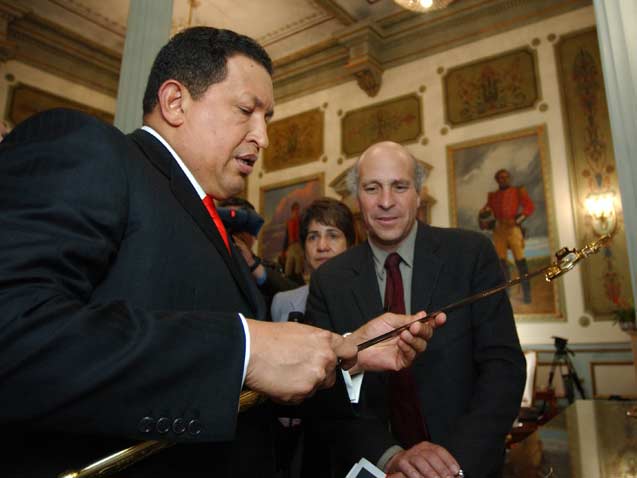 President Hugo Chavez shows reporter Greg Palast the sword of Simon Bolivar seen in portrait in background. Miraflores Palace, Caracas, 2006. (Photo: Richard Rowley)