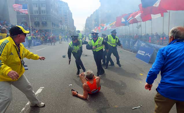 Police officers react to the second explosion near the finish line of the Boston Marathon on Monday, April 15, 2013. Two bombs exploded seconds apart, creating a bloody and chaotic scene about four hours into the race. (Photo: John Tlumacki / The Boston Globe)