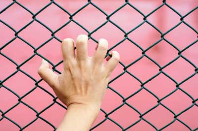 Hand holding fence