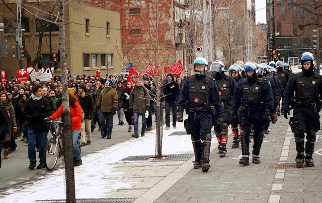 Riot police shadow a protest march against recent austerity measures in Montreal, November 29, 2014.