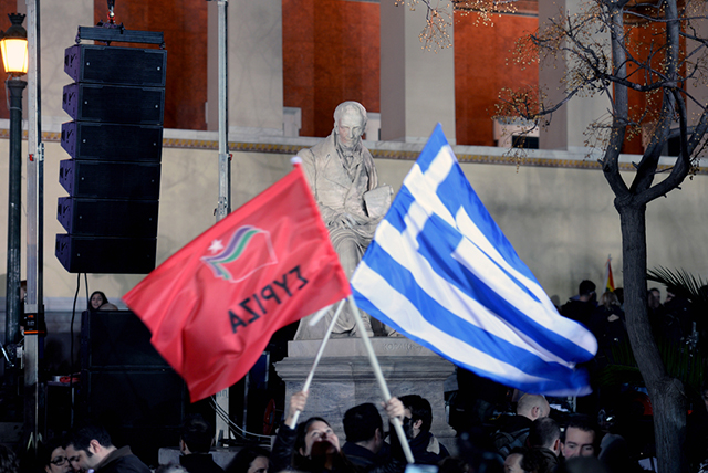 Athens, Greece- 25 January, 2015: Supporters of Syriza left wing party with Greek blue flag and Syriza's red outside Athens University. (Photo via Shutterstock) 