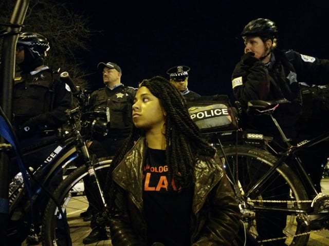Black Youth Project 100 organizer Breanna Champion leads a moment of silence as hundreds of protestors shut down 55th Street on Chicago’s South Side Tuesday night. (Photo: Kelly Hayes)