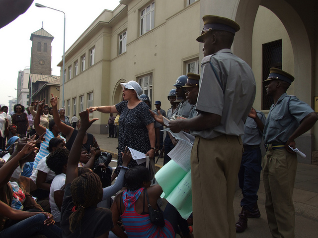 Jenni Williams (in white cap) addresses Women of Zimbabwe Arise members at Zimbabwe’s parliament building in Harare with the police looking on. Zimbabwe is one of the African countries where repression of civic freedoms appears to have intensified. (Photo: Misheck Rusere/IPS)