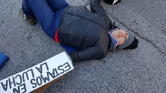 Alicia Avila rests her back against the pavement as she settles into her blockade equipment. (Photo: Kelly Hayes)