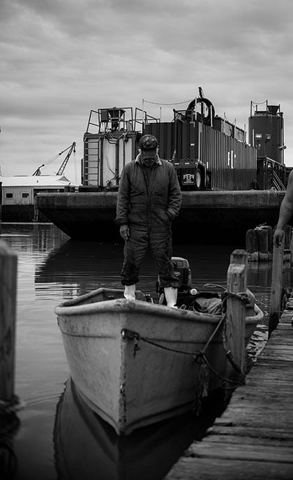 A fisher stands on a boat after unloading the day's catch. (Photo: Michael Stein)