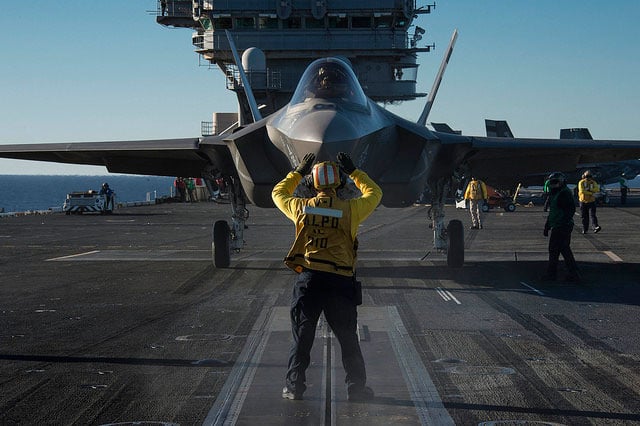 An F-35C Lightning II carrier variant joint strike fighter is prepared for launch during at-sea trials, November 4, 2014. $400 billion and counting has been sunk into the conceptually flawed jet.