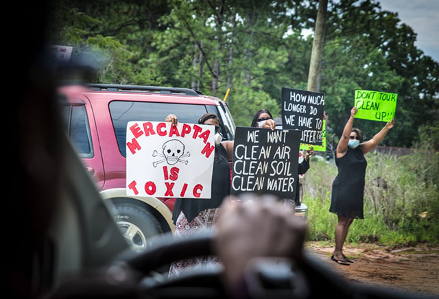 Protesters outside of a Mobile Gas water treatment facility in Eight Mile meet a tour bus leaving the site. (Photo: Julie Dermansky)