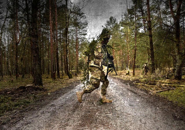 A US Army soldier crosses a road laid through a forest at the Grafenwoehr Training Area in Grafenwoehr, Germany, on February 24, 2016. The Army's newfound involvement with environmental protection is a thin veneer to re-brand its characteristic imperialism. (Photo:The US Army)