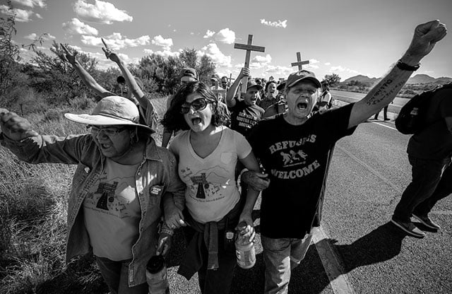Father Roy Bourgeois, SOA Watch founder, alongside Carlota Wrey, founding member of People Helping People, and Eva Lewis, lead a nonviolent direct action march at the US Border Patrol Interior Checkpoint at Hwy. I-19 in Arizona to challenge the legitimacy of checkpoints and demand an end to militarized borderlands. (Photo: Steve Pavey)