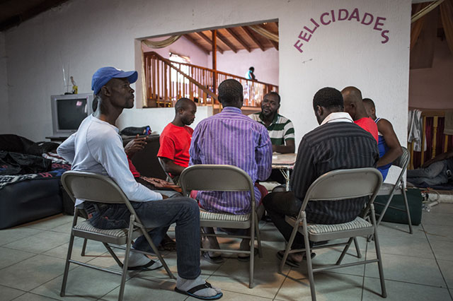 A game of dominoes starts after lunch at the Ambassadors of Jesus church. (Photo: Heriberto Paredes)