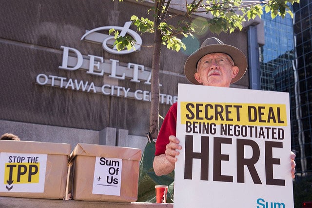 An activist displays a sign at an anti-TPP rally in Ottawa, Canada, on July 10, 2014. (Photo: SumofUs)