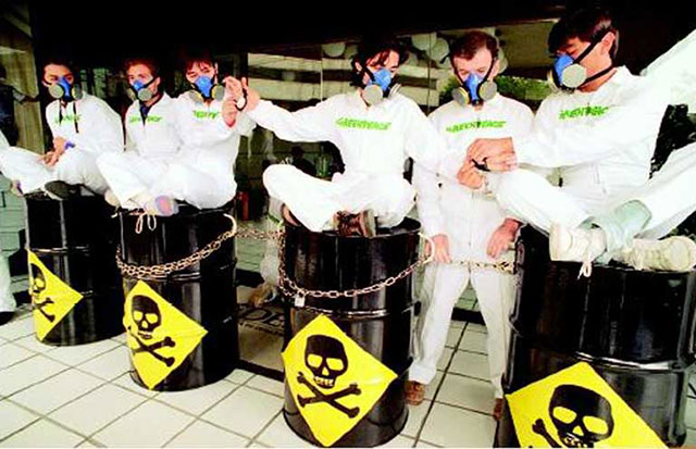 Greenpeace members handcuffed together and sitting on steel drums similar to toxic waste drums outside of the Mexican Office of Environmental Protection, calling attention to the toxic waste disposal facility at Guadalcazar, San Luis Potosi, owned by the U.S. company Metalclad Corporation, Mexico City, Mexico, July 19, 1995. (Photo compliments Greenpeace Mexico)