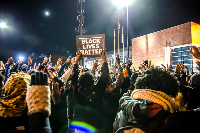 Activists display signs at the #FergusonOctober Vigil and protestfor Mike Brown at the police department in Ferguson, Missouri, on October 11, 2014. (Photo: Sarah-Ji)
