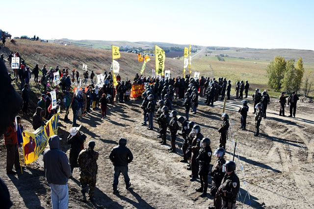 Water Protectors stand off with police in a protest against the continued construction of the Dakota Access pipeline at the Standing Rock camp near Cannon Ball, North Dakota, on October 10, 2016. (Photo: Ellen Davidson)