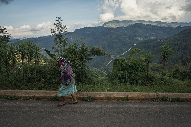 A woman walks down a road above the Aurora dam, one of two hydroelectric dam projects in western Honduras controlled by the husband of Gladis Aurora López, president of the National Party and vice president of Congress. Photo: (Giles Clarke, used with permission courtesy of Global Witness.)
