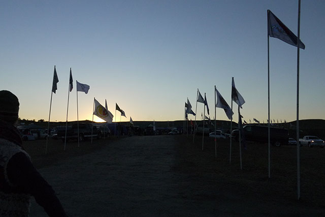 Flags wave at twilight at Standing Rock in September 2016. (Photo: Sarah Jaffe) 