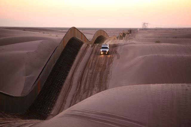 A section of the border wall between the United States and Mexico running across the Imperial Dunes near Yuma Arizona.