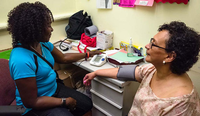 A senior at the Queens Community House receives a blood pressure screening through the Naturally Occurring Retirement Community (NORC) service system. (Photo Courtesy: Queens Community House)