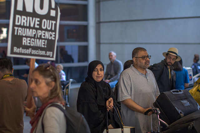 Arriving international travelers pass protesters on the first day of the the partial reinstatement of the Trump travel ban, temporarily barring travelers from six Muslim-majority nations from entering the US, at Los Angeles International Airport on June 29, 2017 in Los Angeles, California. (Photo: David McNew / Getty Images)