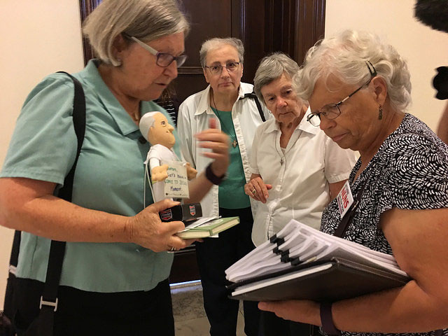 Sister Simone Campbell, Sister Maria Orlandini, Sister Marie Lucey and Sr. Marge Clark review stacks of nuns' letters that they are delivering to the Senate.