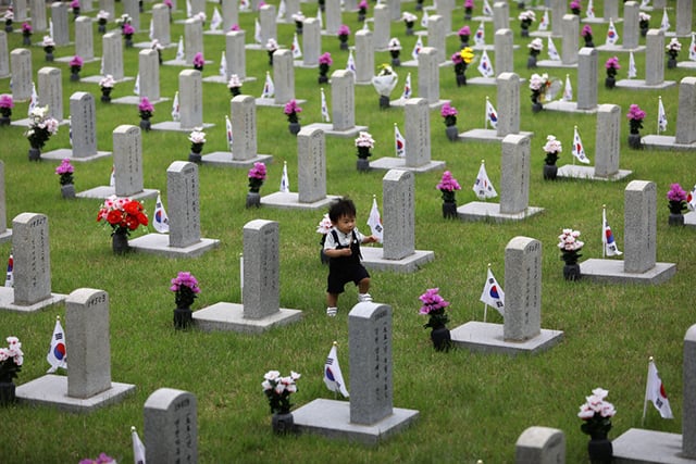 A boy walks by gravestones at the Seoul National Cemetery during a ceremony marking Korean Memorial Day at the Seoul National Cemetery on June 6, 2017, in Seoul, South Korea. South Korea marks the 62th anniversary of the Memorial Day for people who died during the military service in the 1950-53 Korean War. (Photo:  Chung Sung-Jun / Getty Images)