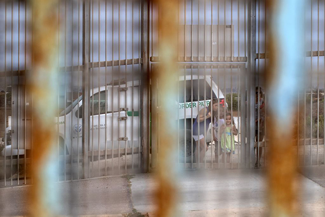 People look at the border through the border fence at the Border Field Park in Playas de Tijuana in Tijuana, northwestern Mexico, on August 22, 2017. The walls and other border enforcement apparatus on the US-Mexican border are increasingly a barrier to keep climate refugees out of the United States. (Photo: GUILLERMO ARIAS / AFP/ Getty Images)