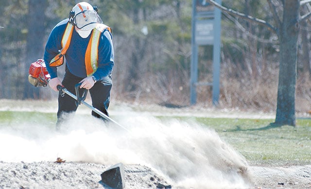 Using a mask to keep the silica dust from entering his lungs, an employee of Maine State Highway Maintenance Department sweeps a large quantity of the the harmful salt laced road sand. Unions say hundreds of workers die each year from silica exposure, but William Wehrum argued on behalf of industry groups that new standards go too far. 