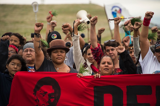 Native Americans march to a burial ground sacred site that was disturbed by bulldozers building the Dakota Access Pipeline (DAPL), near the encampment where hundreds of people have gathered to join the Standing Rock Sioux Tribe's protest of the oil pipeline that is slated to cross the Missouri River nearby, September 4, 2016 near Cannon Ball, North Dakota. / AFP / Robyn BECK