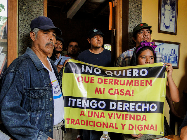 Residents hold a sign that says: “I don't want my house demolished. I have the right to a traditional and dignified house.” (Photo: Santiago Navarro F.)