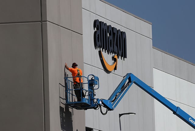 A worker makes repairs to a wall at a new Amazon fulfillment center on August 10, 2017, in Sacramento, California. (Photo: Justin Sullivan / Getty Images)