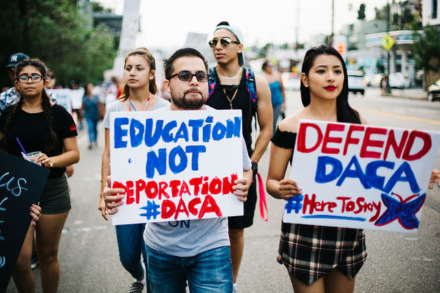 Activists display signs at a march for immigrant rights on September 11, 2017, in Los Angeles, California. (Photo: Molly Adams)
