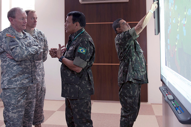 Army Gen. Martin E. Dempsey and Army Col. Sam Prugh, Defense Attach&eacute;, listen to a staff member explain what members at the jungle training center learn in the classroom in Manaus, Brazil, on March 28, 2012. (DOD photo by US Army Staff Sgt. Sun L. Vega, Joint Staff)
