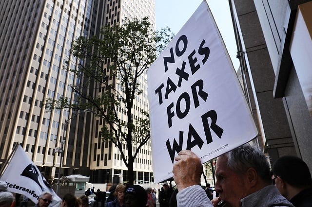  Protesters converge outside of the Internal Revenue Service on tax day in lower Manhattan to protest tax dollars being spent on the military on April 18, 2017 in New York City. Over twenty demonstrators chanted and sang anti-war songs during the afternoon rush. U.S. President Donald Trump has launched numerous missile strikes and championed the U.S. military in recent weeks, angering those who oppose his policies. (Photo by Spencer Platt/Getty Images)