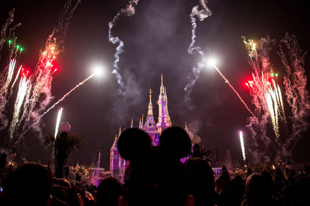 Visitors watch fireworks exploding over the Disney castle at Shanghai Disneyland in Shanghai on December 20, 2017. (Photo: Chandan Khanna / AFP / Getty Images)