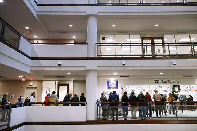 Residents wait in line to pay taxes at the Fairfax County Government Center December 28, 2017 in Fairfax, Virginia. Many people are pre-paying their 2018 property taxes before the end of the calendar year in an attempt to blunt the effects of the new Republican tax law's $10,000 cap on deductions for state and local taxes that will disproportionately affect higher-tax, Democratic-leaning states. (Photo: Chip Somodevilla / Getty Images)