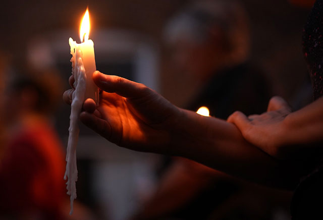 People raise their memorial candles during a vigil at the location where 32-year-old Heather Heyer was killed when a car plowed into a crowd of people protesting against the white supremacist Unite the Right rally August 13, 2017, in Charlottesville, Virginia. (Photo: Win McNamee / Getty Images)