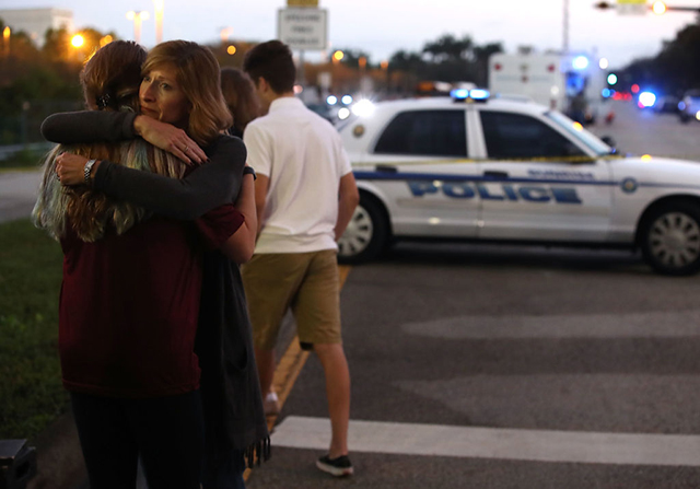 Kristi Gilroy hugs a young woman at a police checkpoint near the Marjory Stoneman Douglas High School where 17 people were killed by a mass shooter on February 15, 2018, in Parkland, Florida. (Photo: Mark Wilson / Getty Images)