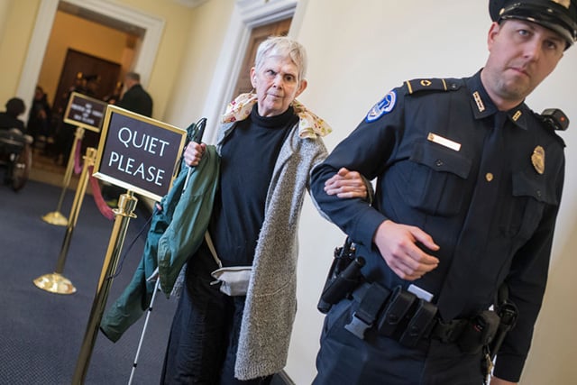 Harriotte Ranvig, 71, is escorted out of the House chamber on February 15, 2018, after she and a group of protesters disrupted the vote on the ADA Education and Reform Act, which makes it harder for disabled people to sue for discrimination. (Photo: Tom Williams / CQ Roll Call)