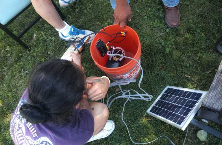 Gloria Red Cloud shows off a solar-powered floodlight she built for her car using about $100 in materials. (Photo: Saul Elbein)