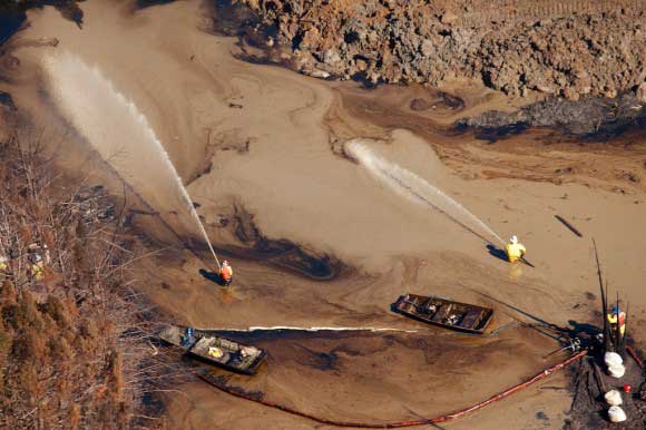 Workers spraying oil at the train wreck and crude spill near Aliceville. (Photo: John Wathen)