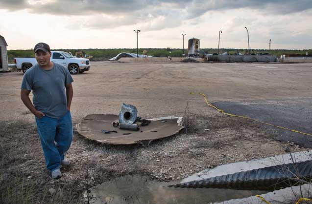 Worker standing guard at the remains of saltwater disposal plant that exploded. (Photo: ©2013 Julie Dermansky)