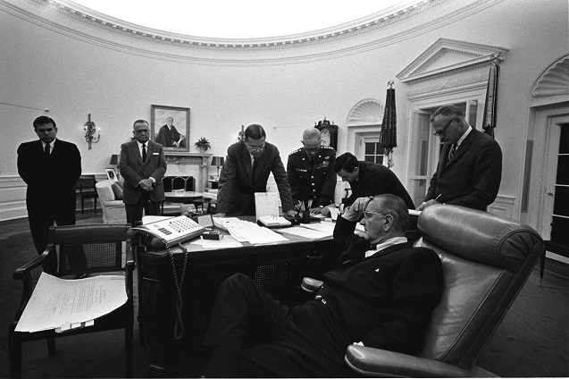 Oval Office meeting on the Detriot riots, July 24, 1967. President Lyndon B. Johnson (seated, foreground) working with (background L-R): Marvin Watson, J. Edgar Hoover, Sec. Robert McNamara, Gen. Harold Johnson, Joe Califano, Sec. Of the Army Stanley Resor. (Photo: <a href=