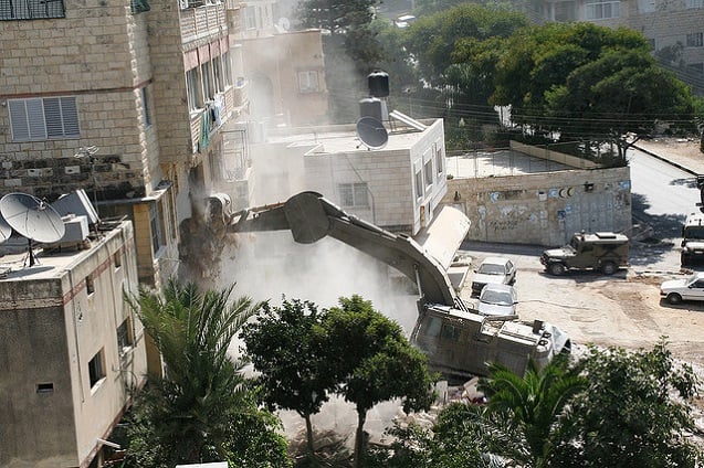 A Caterpillar Excavator destroys homes in Nablus, Palestine, August 26, 2006. (Photo: <a href=