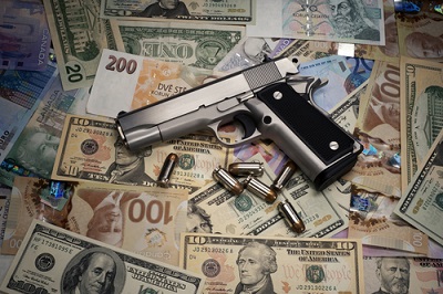Gun and money. (Image <a href=
