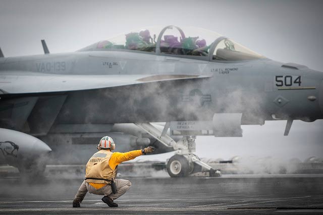 A shooter signals an EA-18G Growler aboard USS Carl Vinson.