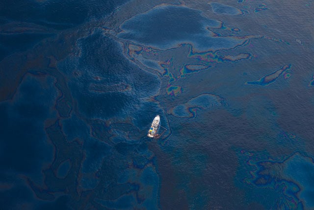 A ship floats amongst a sea of spilled oil in the Gulf of Mexico after the BP Deepwater Horizon oil disaster. Large-scale spills like this one are only the tip of the iceberg when it comes to the environmental impacts of offshore drilling.