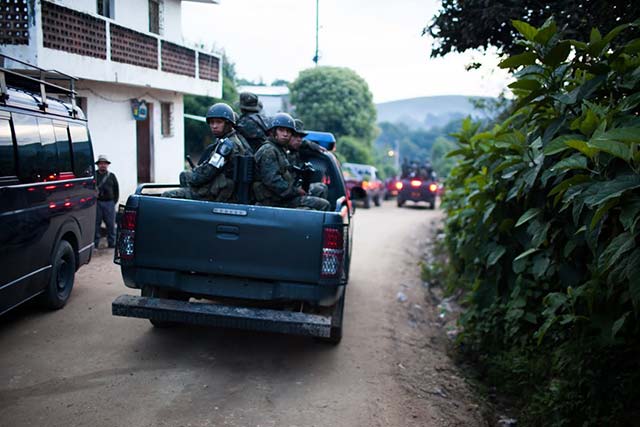 A patrol of soldiers passes through the community of Pajoques in San Juan Sacatepéquez in October 2014. (Photo: Jeff Abbott)