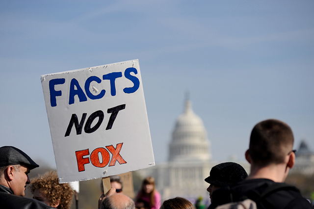 30 October, 2010: A demonstrator holds a sign at the Rally to Restore Sanity and/or Fear on the National Mall on October 30, 2010 in Washington. (Photo via Shutterstock)