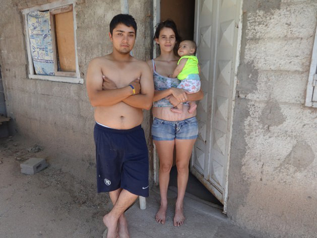 A couple outside their home in a poor neighbourhood in the town of Malvinas Argentinas in the central province of Córdoba. The three members of the family are among the beneficiaries of Argentina’s social programmes. (Photo: Fabiana Frayssinet / IPS)