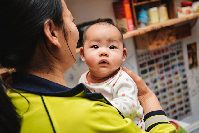 Ivy Gao with her daughter Sophia, 4 months, in their unit in a Chinatown single-room occupancy hotel. (Photo: Tudor Stanley)